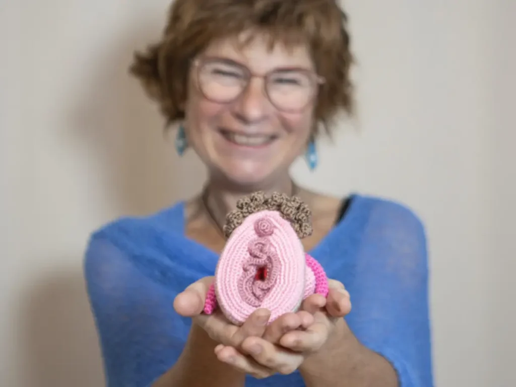 Mireia Grossmann mostrando un modelo anatómico de genitales femeninos tejido a mano, para educación sexual y salud del suelo pélvico.