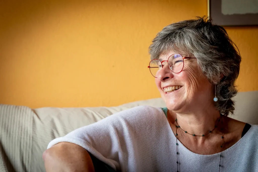 Mujer sonriendo mientras habla de endometriosis y menopausia precoz desde una mirada positiva y cercana.